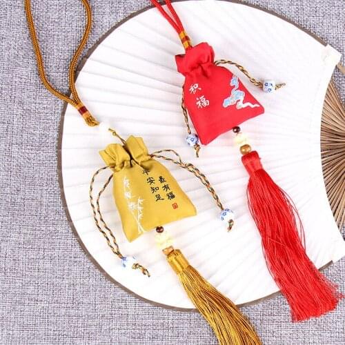 Gufeng carries sachets with finished bags containing dried herbs to protect the health and safety of family members and children