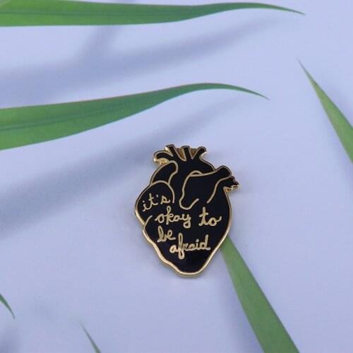Its okay to be afraid enamel pin. Black and gold anatomical heart lapel pin