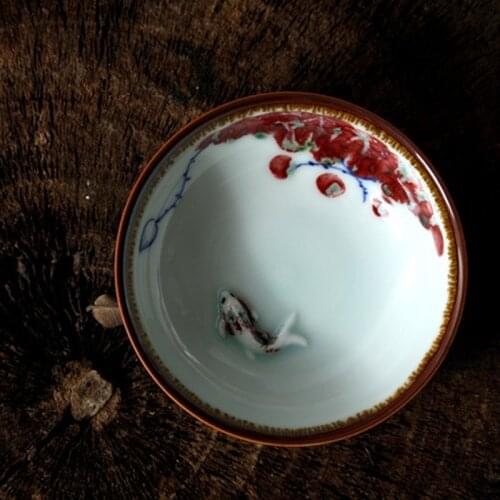 Hand-painted blue and white ceramic tea cup embossed fish Pu'er tea cup porcelain glaze red spot 80ml tea bowl