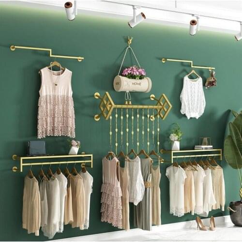 On the display shelf of a clothing store wall hanging shop display shelf gold hanging clothes shelf wall