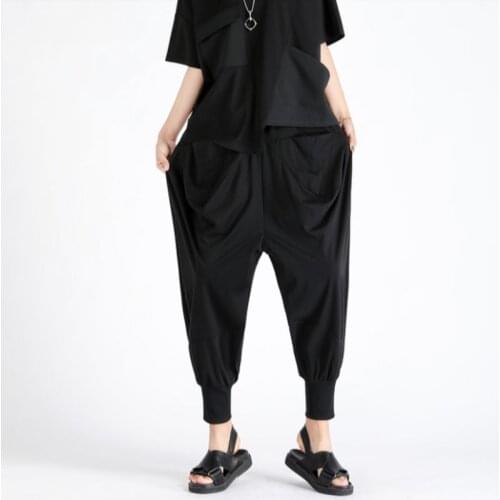 Black tracksuit pants with symmetrical ruffled pockets and elastic waists