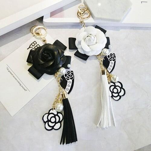 PU leather tassel black and white female keychain plush car camellia bag pendant car key ring mobile phone shell decoration