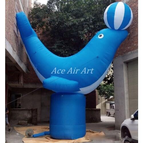 Blue inflatable dolphin lying on pillar with ball over head mascot animal model for oceanarium advertising/marine zoo display