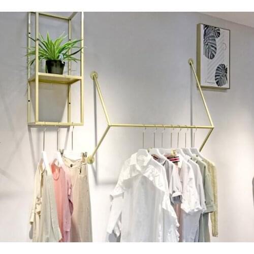 On the display shelf of the clothing store, the wall is hung on the shelf of the womens clothing store
