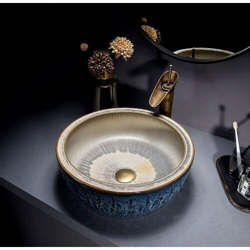 Creative kiln-glazed washbasin on ceramic art table; retro style washbasin in bathroom; household round washbasin