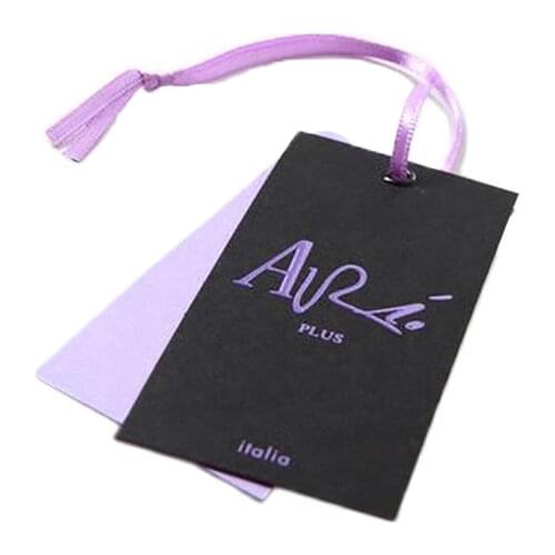 White cardboard garment labels swing tags with purple ribbon