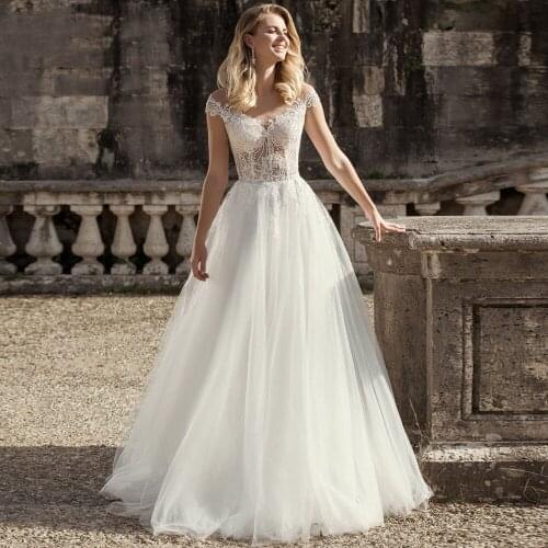 See Through Scoop Neck A-line Tulle Wedding Dresses 2021 Chic Lace Appliques Buttons Back Floor Length Cap Sleeves Bridal Gown