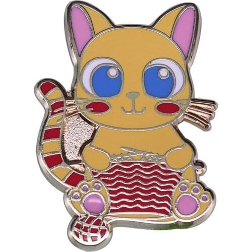 This brooch is a must-have for any knitter! Featuring a cat knitting sweater