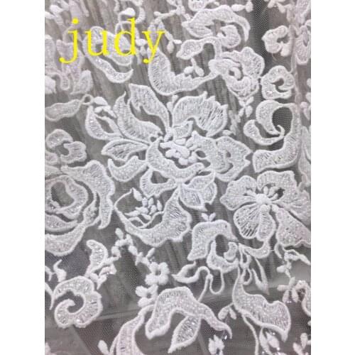 Stock White embroidery with dense hand-beaded flowers and luxurious French fabrics are used for bridal gowns and stage fashions