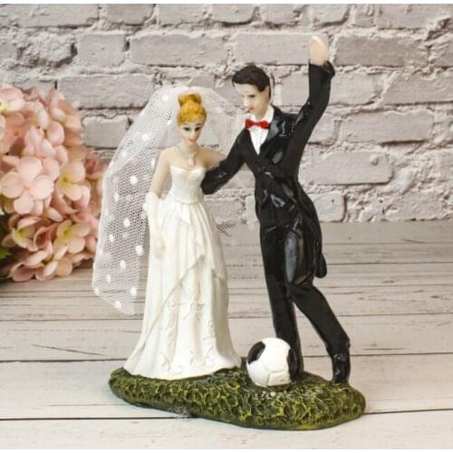 Bride and groom holding the bouquet and wearing a football uniform affectionate looked at resin figurines cake topper wedding