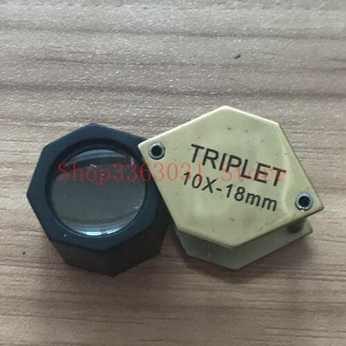 Jewelers loupe jewelry using gold illuminated magnifier