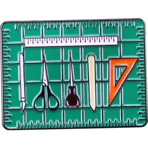 Book Artist Tool Kit Pin triangle bone folder ruler awl scissors x-acto knife on a cutting mat brooch bookbinders and book artis