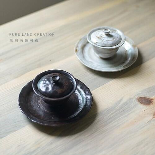Pure handmade coarse pottery bowl covered with a single handmade kungfu tea set with ceramic hand clutching sancai tea cup