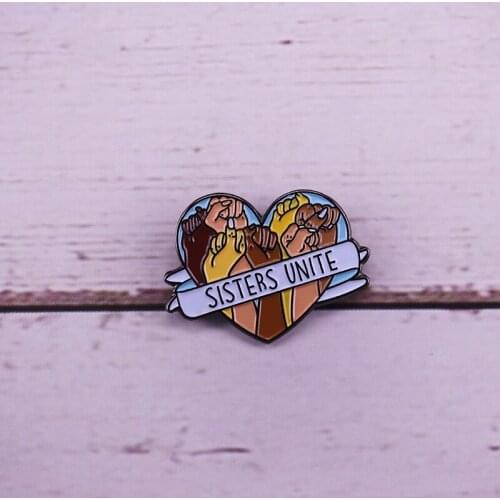 A stunning black and pastel soft enamel sisters unite pin badge
