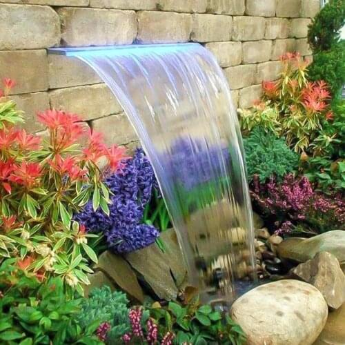 Swimming pool waterfall flowing water wall. Landscape pool flowing water waterfall .Circulating water outlet of Koi fish pond