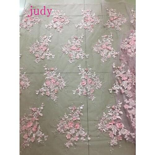 Pink flowers embroidered pearls decorated with artificial diamonds are used in luxury fabrics for gowns and wedding dresses