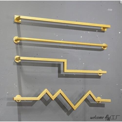 Golden wall hanging rack in clothing store front and side hanging rack in mens and womens clothing store