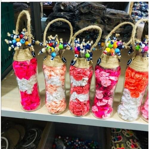 Rose Shaped Leaves Stuffed Glass Bottle With Evil Eyes Bundle On The Tap