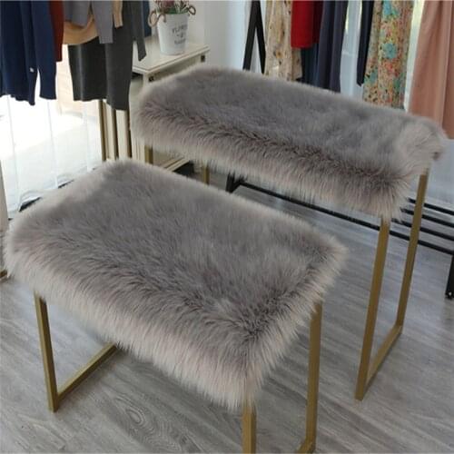 Articles placed long plush artificial fur, table top covered with fluffy blanket, rectangular fluffy cushion