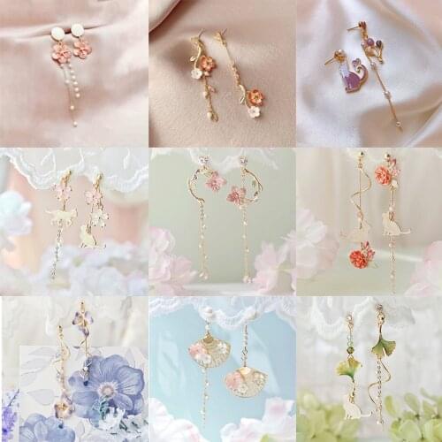 Korean version of retro asymmetric butterfly imitation pearl earrings fashion round flower tassel long wings earrings jewelry