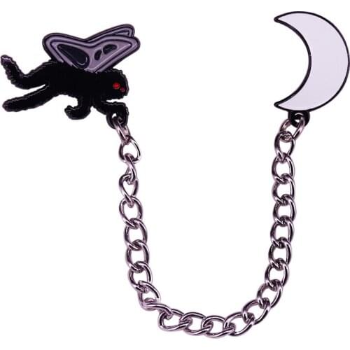 The mothman and crescent moon attached by a chain pin