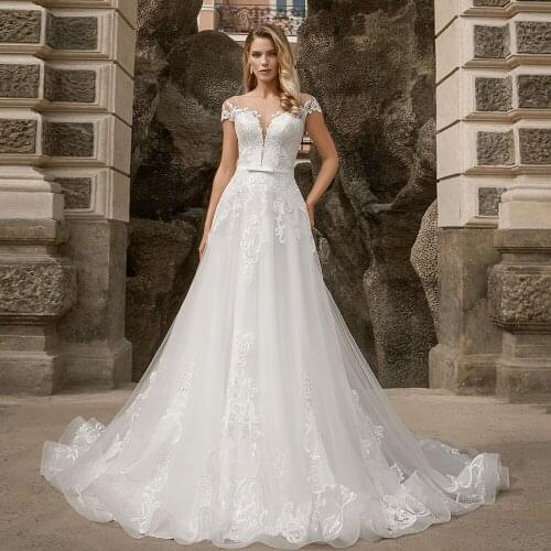 Gorgeous A-Line Tulle Wedding Dresses 2021 Sheer O-Neck Cap Sleeve Lace Appliques Sweep Train Button Bridal Gown With Bow Belt