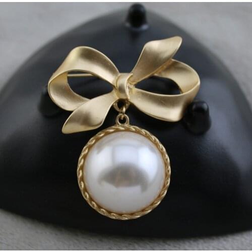 And American fashion alloy classic matte gold bowknot big female spot of pearl inlaid brooch street vendor was elected