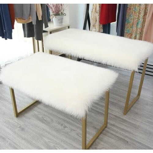 Plush Faux Fur table top laid with rectangular fluffy cushion items placed fluffy covered table blanket