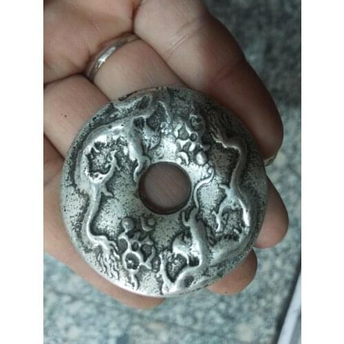 Las monedas chinas antiguas de plata del Tíbet talladas con personajes antiguos y la hebilla del dragón y Fénix Fen